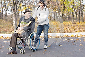 Woman helping a disabled pensioner in a wheelchair