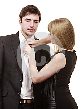 Woman helping man dress up elegant clothes.