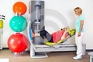 Woman helping patient strengthen her legs