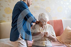 Woman helping senior woman dress photo