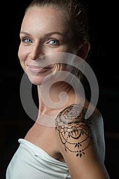 Woman with henna tattoo on her shoulder