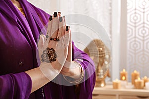 Woman with henna tattoos on hands indoors, closeup and space for text. Traditional mehndi ornament