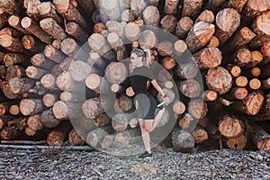 Woman in her 40s making exercise outdoors in a sunny day and stretching. Healthy life and sport lifestyle concept. Wood trunks