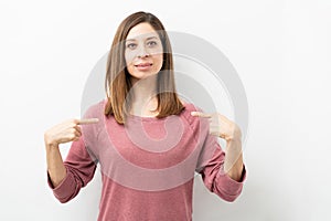 Woman in her 40s pointing at herself