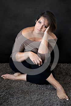 Woman in her 40s sitting on the floor