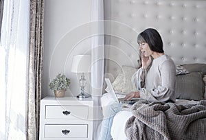 Woman on her bed with a laptop depicting moods