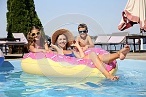 Woman with her children in swimming pool.