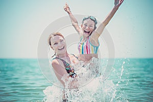 Woman and her daughter having fun in the sea.