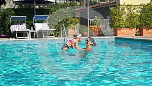 Woman and her Daughter Playing in a Pool Outdoors