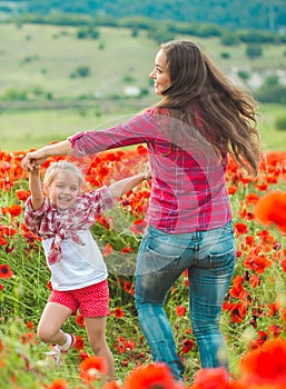 Woman and her daughter in poppy field