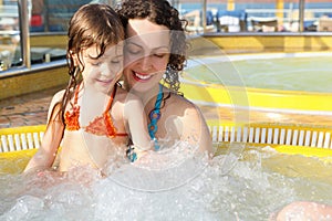 Woman with her daughter is relaxing in hot tub