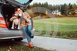 Woman with her dog have a tea time during their autumn auto travel