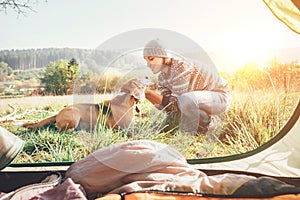 Woman and her dog tender scene near the camping tent. Active leisure, traveling with pet6 simple things concept image