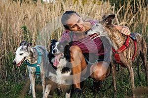 Woman with her dogs resting during dog walking outdoors