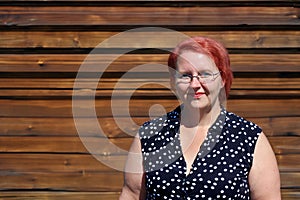 woman in her forties against a wood stained background