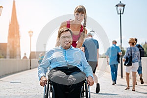 Woman and her friend in a wheelchair having stroll through the town