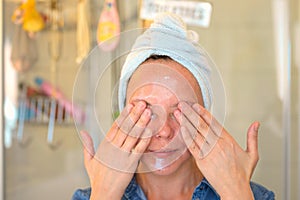 Woman applying moisturiser or cleansing cream