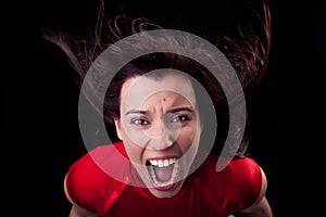 Woman with her hair in wind,screaming in fury photo