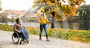 Woman and her handicapped boyfriend in wheelchair, wearing FFP2 during covid-19 pandemic