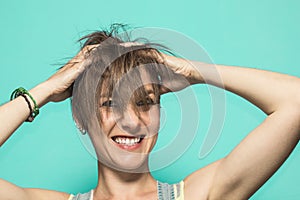 Woman with her hands on her head, clutching her hair.