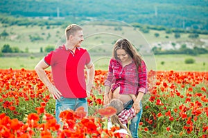 Woman her husband and their daughter in poppy field