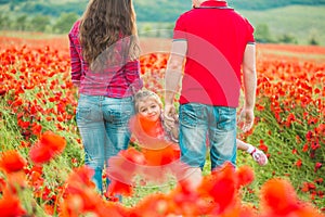 Woman her husband and their daughter in poppy field