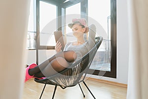 Woman in her living room relaxing reading a book