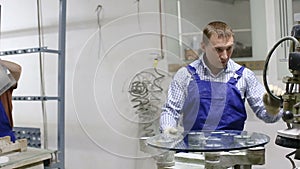 Woman and her male colleague working at glass factory