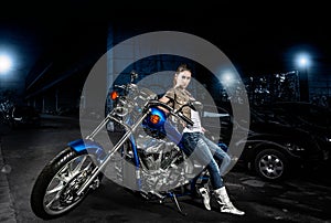 Woman and her motorbike outdoors at night