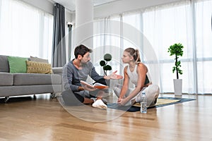 Woman with her personal fitness trainer. Couple exercising together. Man and woman in sports wear doing workout at home. Healthy