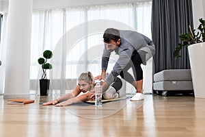 Woman with her personal fitness trainer. Couple exercising together. Man and woman in sports wear doing workout at home. Healthy