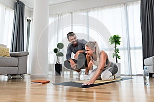 Woman with her personal fitness trainer. Couple exercising together. Man and woman in sports wear doing workout at home. Healthy