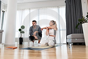 Woman with her personal fitness trainer. Couple exercising together. Man and woman in sports wear doing workout at home. Healthy