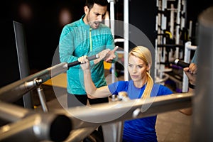 Woman with her personal fitness trainer in the gym exercising