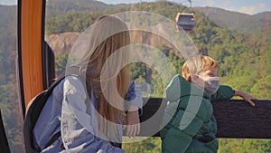 A woman and her son ride in a cable car up the mountain to the Ba Na Hills resort in the city of Danang