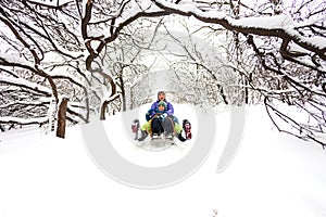 A woman with her son rides down the hill in a sleigh and screaming