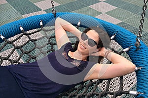 Woman in her thirties (30s) daydreaming about life on a swing i