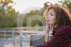 Woman in her thirties thinking as the sun sets