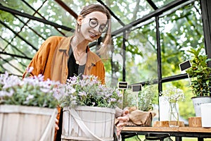 Woman with herbs and flowers in the greenhouse