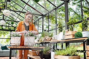 Woman with herbs and flowers in the greenhouse