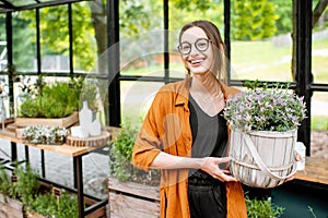 Woman with herbs and flowers in the greenhouse