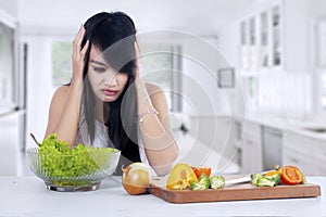 Woman hesitate to eat salad photo