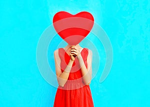 woman hides her head red an air balloons on blue background