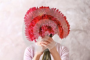 Woman hiding behind beautiful dahlia flowers