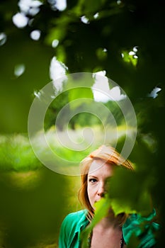 Woman hiding behind leaves