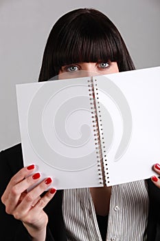 Woman hiding behind notebook