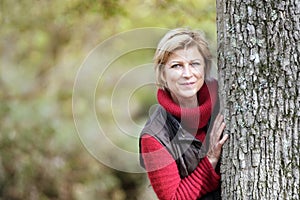 Woman hiding behind a tree