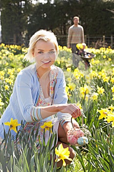 Woman Hiding Decorated Easter Eggs For Hunt