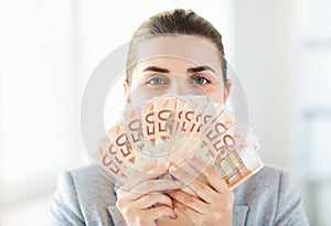 Woman hiding her face behind euro money fan