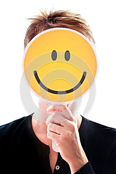 Woman hiding her face behind a smiley